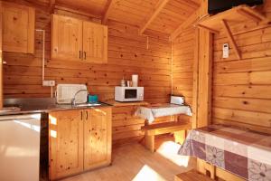 オルノスにあるCamping Montillana con Bungalowsの木造キャビンのキッチン(電子レンジ付)