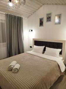 a bedroom with a large bed with towels on it at Family House Volosianka in Volosyanka