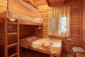 オルノスにあるCamping Montillana con Bungalowsの丸太小屋の二段ベッドが2つある寝室 +107枚の写真