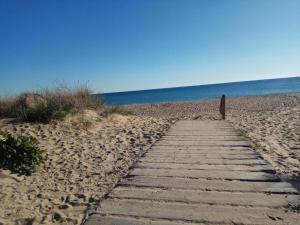a wooden path on a sandy beach near the ocean at Islantilla ático 1 línea de playa vistas al mar in Islantilla