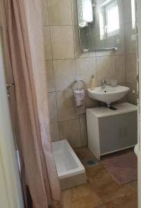 a bathroom with a sink and a shower curtain at Apartman Fantina 2 in Sveti Filip i Jakov