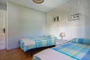 a bedroom with two beds and a white door at Appto Turístico La Franca LFRA002R in La Franca