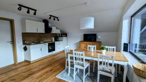a kitchen and dining room with a wooden table and chairs at Ferienwohnung Alpenlift in Bolsterlang Sommerbergbahn kostenlos in Bolsterlang +21 photos
