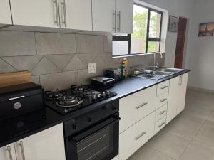 a kitchen with a black stove and a sink at Royal On Olifant Drive in Marloth Park
