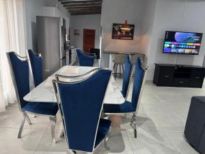 a dining room with blue chairs and a table at Royal On Olifant Drive in Marloth Park