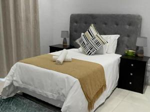a bedroom with a large bed with white sheets and pillows at Royal On Olifant Drive in Marloth Park