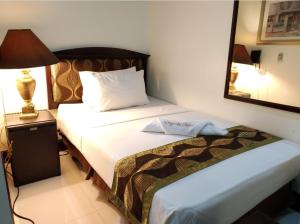 a hotel room with two beds and a mirror at Ongville Hotel & Events Place in Candelaria