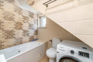 a bathroom with a toilet and a washer and dryer at Beach Apt 1 In Burgau in Burgau