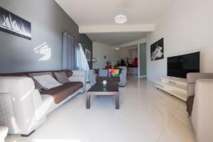 a living room with a couch and a tv at Riva Sagara by IHR in Flic-en-Flac