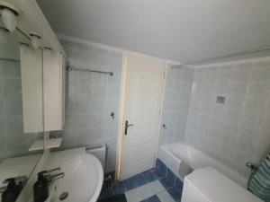 a bathroom with a sink and a toilet and a tub at Gik Houses in Zacharo