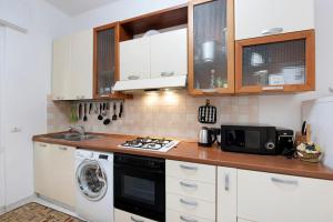 a kitchen with white cabinets and a washer and dryer at Leo! Intero appartamento ad uso ESCLUSIVO - Aeroporto Genova Sestri Ponente in Genova +17 photos