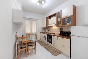 a kitchen with white appliances and a table and chairs at Leo! Intero appartamento ad uso ESCLUSIVO - Aeroporto Genova Sestri Ponente in Genova