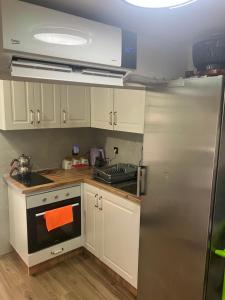 a kitchen with white cabinets and a stainless steel refrigerator at Villa Adushi in Prizren +12 photos