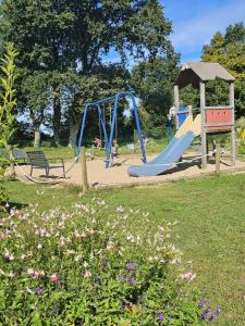 un patio de recreo en un parque con un tobogán en Camping 3 étoiles - Piscine - eec0di, en Fouesnant