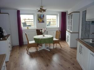 Una cocina con mesa y sillas y dos ventanas. en Rosi's Kuschelapartment, en Geisenheim 12 fotos más