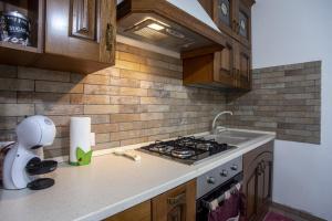 a kitchen with a stove top and a sink at S'apposentu in SantʼAnna Arresi +11 photos