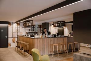a man standing at a bar in a restaurant at Armon Greenblu Hotel & Wellness in Folgarida
