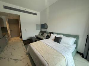 ドバイにあるBrand New Chic Studio Apartment 8min to Downtownの大きなベッドとソファのある寝室