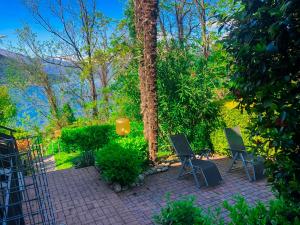 a patio with two chairs and a tree at Parco Ameno by Lago Reisen in Germignaga