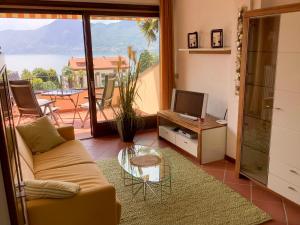 a living room with a couch and a television at Parco Ameno by Lago Reisen in Germignaga