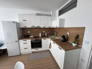 a kitchen with white cabinets and a sink at Apartment Bela in Burgas City