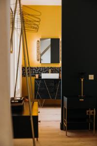 bagno con parete gialla e specchio di Château de Neyran chambre d'hôtes & Spa a Soulac-sur-Mer