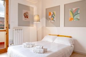 a bedroom with a white bed with towels on it at Homiday- New Apt- Free Parking- Aeroporto - Ospedale in Pisa +7 photos