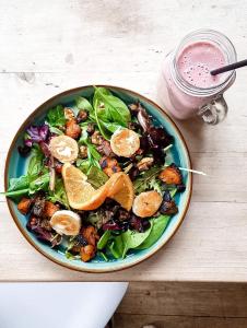 a salad in a blue plate on a table with a drink at Funky London Studio, Comfort Meets Style in London +3 photos