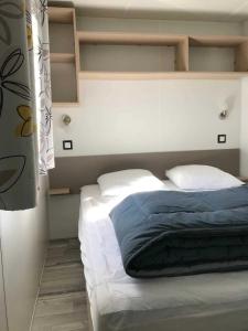 a bed with two pillows at Camping 4 étoiles - Piscine - eecaad in Aureilhan