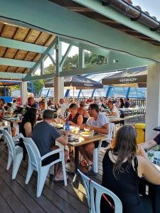 a group of people sitting at tables in a restaurant at Camping 4 étoiles - Piscine - eecaad in Aureilhan