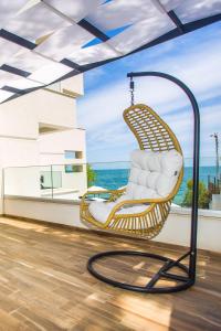 a wicker rocking chair on the balcony of a house at Olive Villas Beach Hotel in Sozopol