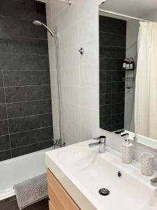 a bathroom with a white sink and a shower at Casa Rural Las Candelas in San Vicente de Alcántara