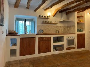 a large kitchen with wooden cabinets and a sink at Cortijo La Pedriza in Iznájar