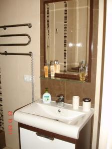 y baño con lavabo blanco y espejo. en Most City Premium apartments, en Dnipro