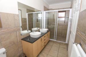 a bathroom with two sinks and a shower at River Bend Farm in Lidgetton