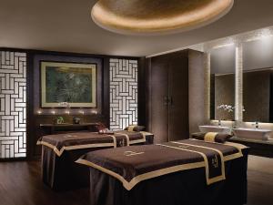 a room with two beds and a sink and a bathroom at Langham Place Guangzhou - Walking distance to Canton Fair in Guangzhou