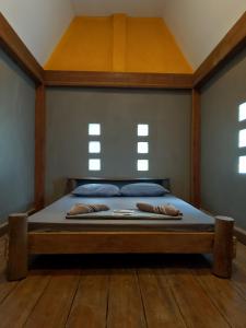 a bedroom with a bed with a wooden frame and windows at Lazy Bones in Koh Rong Sanloem