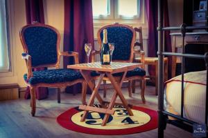 a table with a bottle of wine on it with two chairs at The Originals Boutique, Hôtel Roca-Fortis, Rochefort in Rochefort