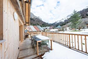 una terrazza con tavolo e sedie nella neve di La grange de Fernande - 8 personnes a Jarsy