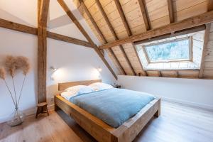 una camera da letto con un letto in una stanza con soffitti in legno di La grange de Fernande - 8 personnes a Jarsy