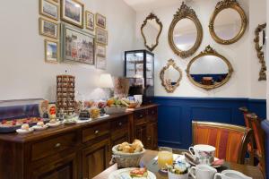 - une salle à manger avec une table, de la nourriture et des miroirs dans l'établissement Hotel Mogador, à Paris