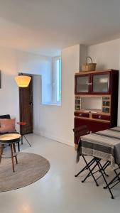 a living room with a table and a chair at Oléron MaisonMer in Le Château-dʼOléron