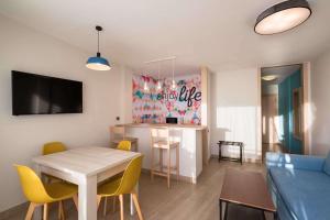 un salon avec une table et des chaises jaunes dans l'établissement Allegro Isora, à Puerto de Santiago