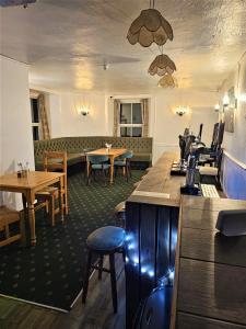 a restaurant with tables and chairs and a bar at Prestleigh Inn in Shepton Mallet
