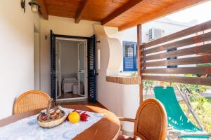 a table and chairs on a balcony with a view at Villaggio Residence Emmesse Appartamento Standard in Mandaradoni