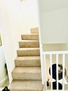 eine Treppe mit Teppichboden und einer Treppe in der Unterkunft Castleford Cottage , Lowermill Estate in Somerford Keynes