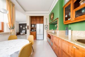 a kitchen with green walls and a white counter top at Royal Wilanów Spacious Apartment by BookingHost in Warsaw