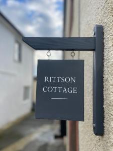 un cartello che legge "cottage" su un edificio di Cosy Cottage Stay Book & Unwind a Penrith