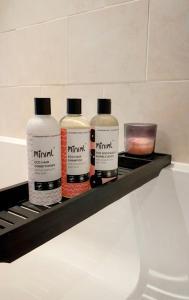 tre bottiglie di crema idratante sedute su uno scaffale di Cosy Cottage Stay Book & Unwind a Penrith