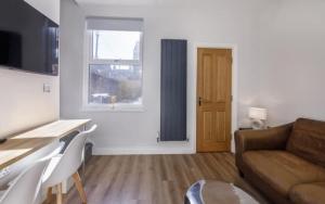 a living room with a couch and a table at 4 bedroom house close to Walmgate bar sleeps 7 in York